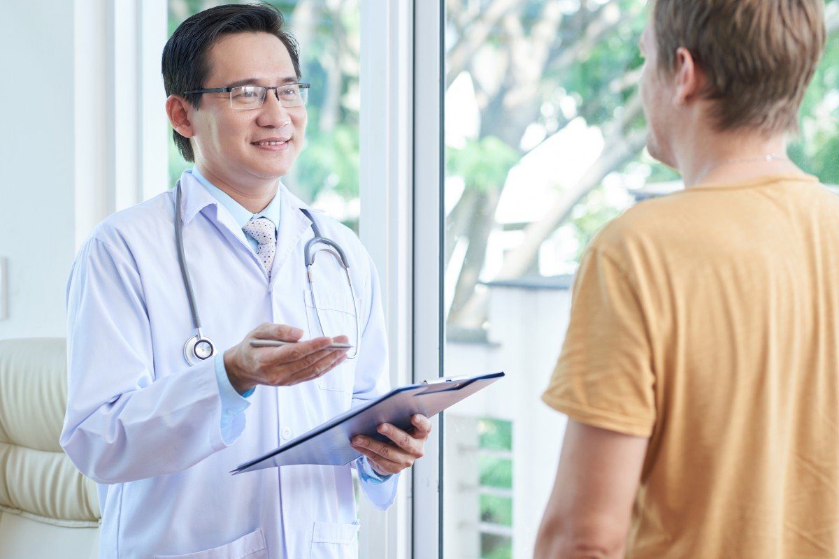 Médico conversa con su paciente y revisa su historial clínico durante una consulta en el consultorio